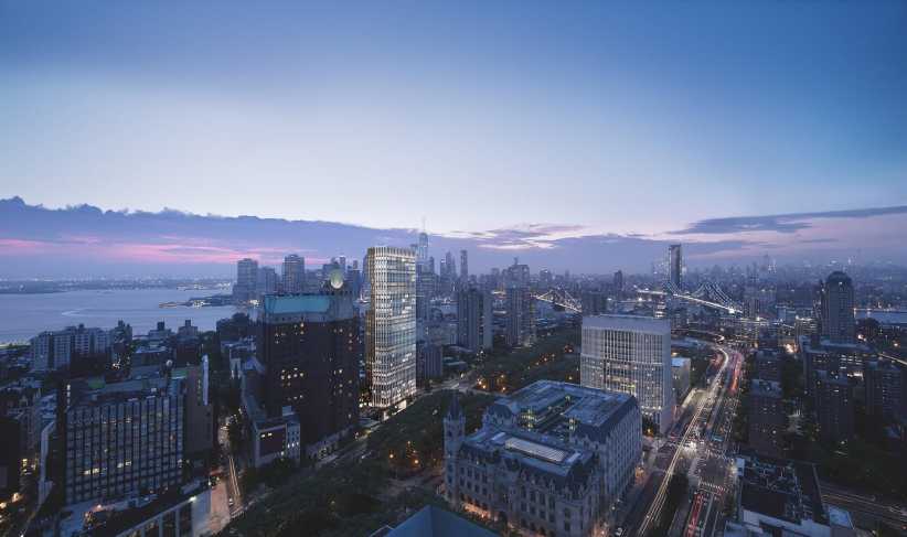 Aerial cityscape at dusk featuring modern high-rise and historic buildings, busy streets, bridges, and a river under a blue sky.