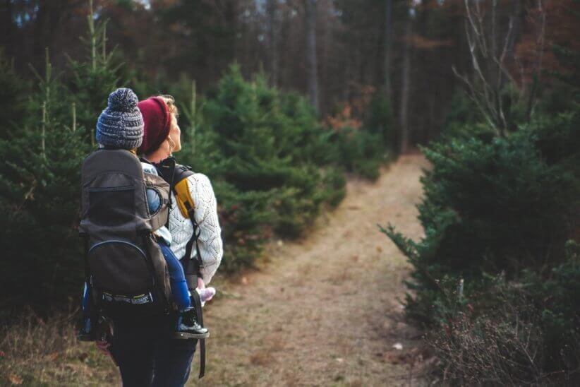 mom taking a hike with child on back