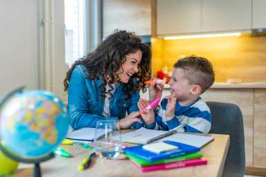 Mother and son drawing together, mom helping with homework