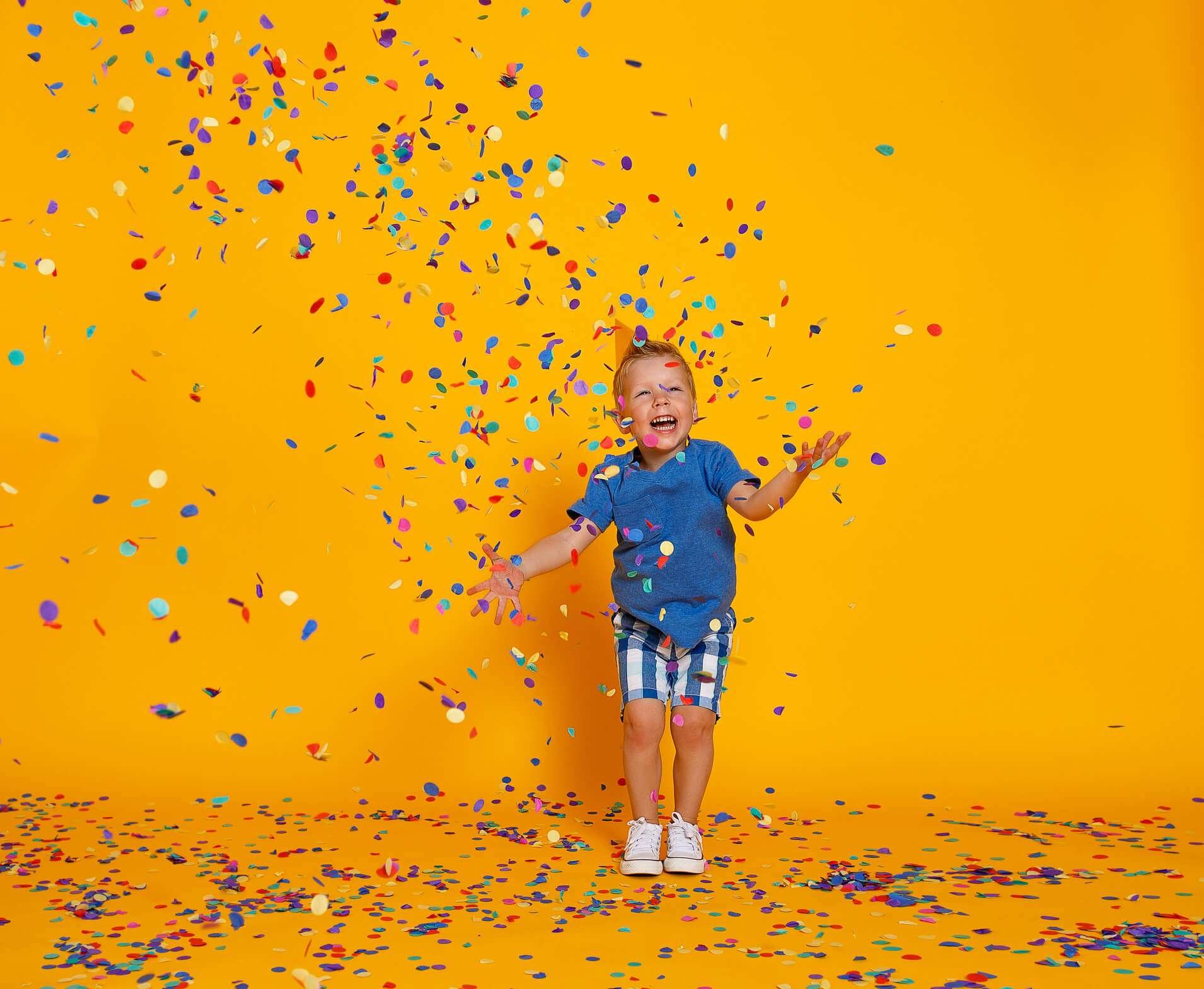 happy birthday child boy with confetti on yellow background