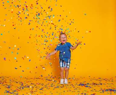 happy birthday child boy with confetti on yellow background