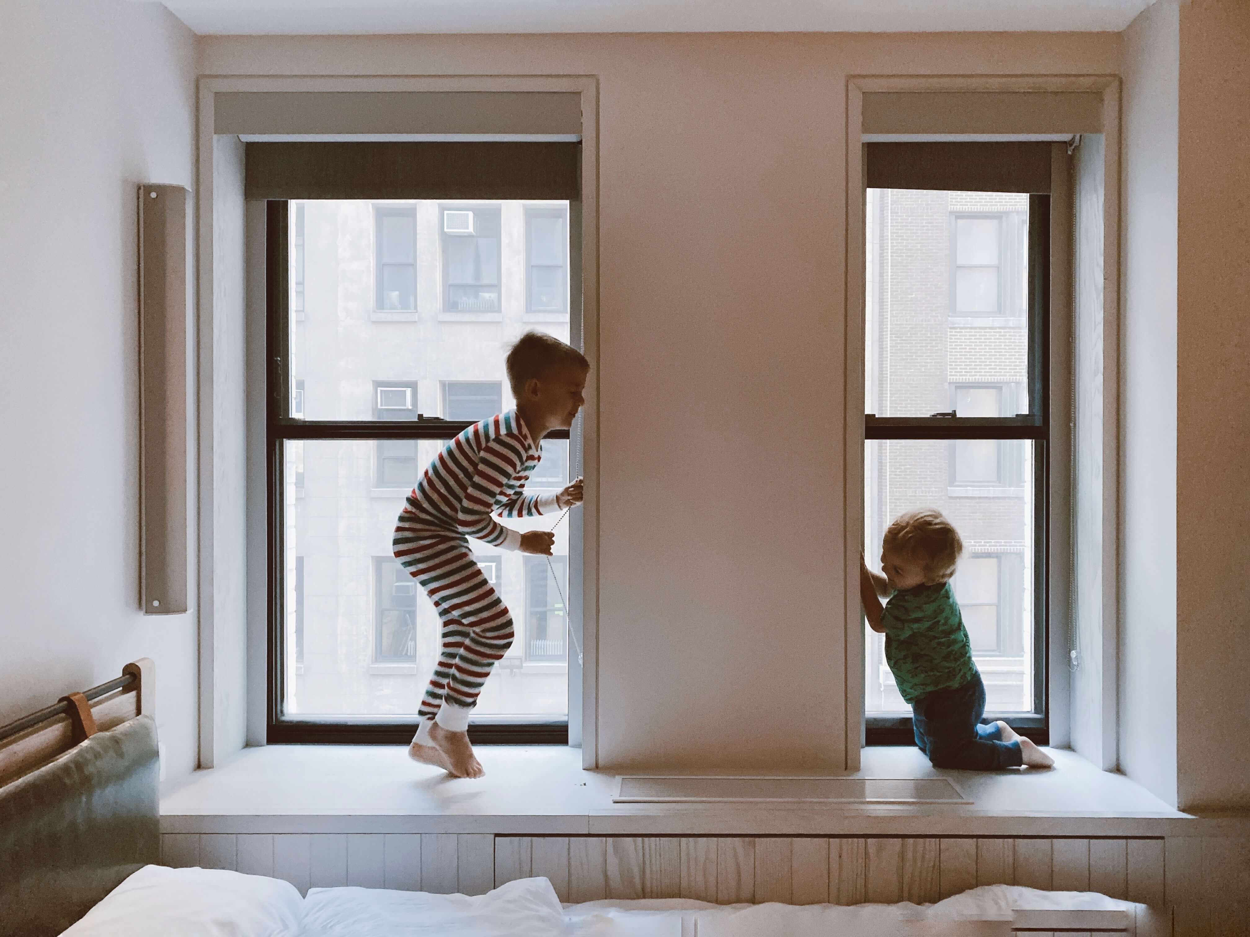 two-kids-playing-beside-glass-windows-3273851