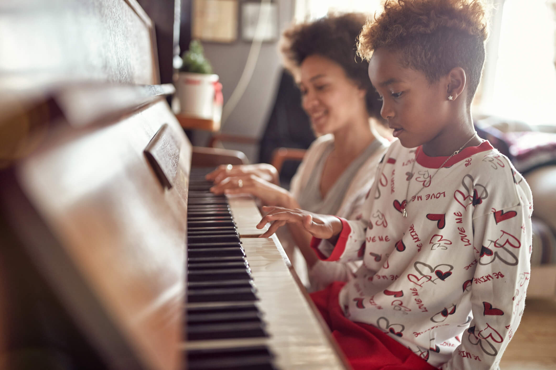 girl is playing on piano x-mas music. Concept Christmas, New Year, holiday, family happiness, childhood.