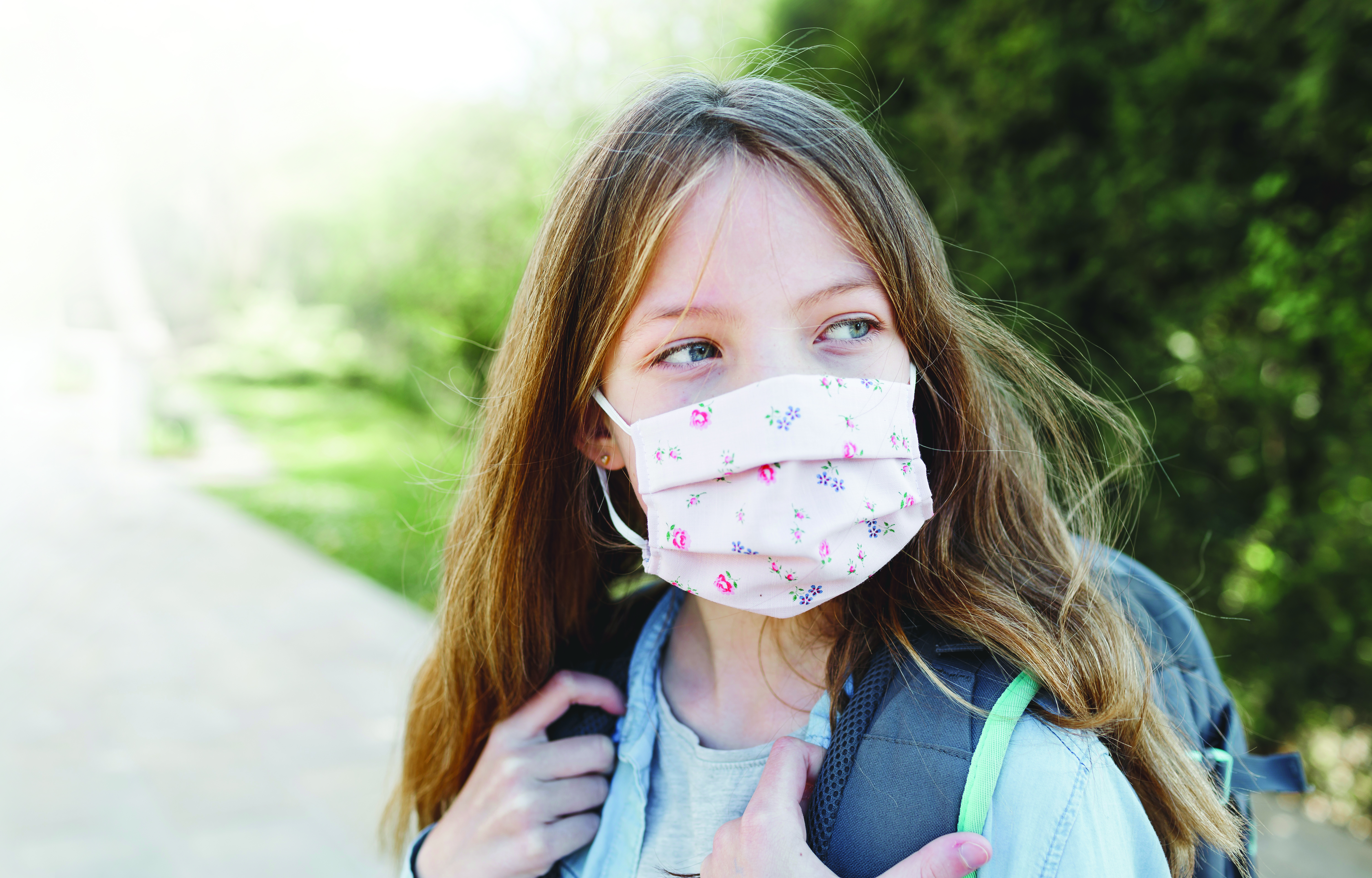 pretty girl with nose mouth mask goes to school