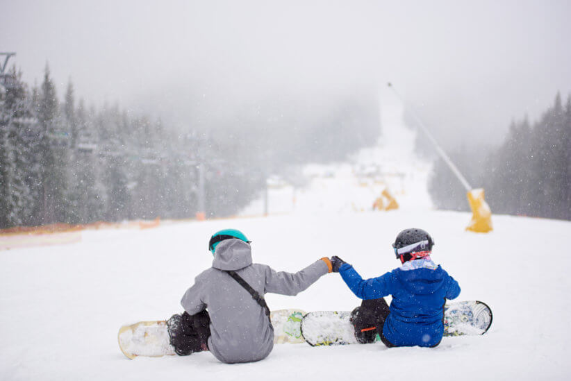 snowboarders sitting down at family-friendly ski resort new york