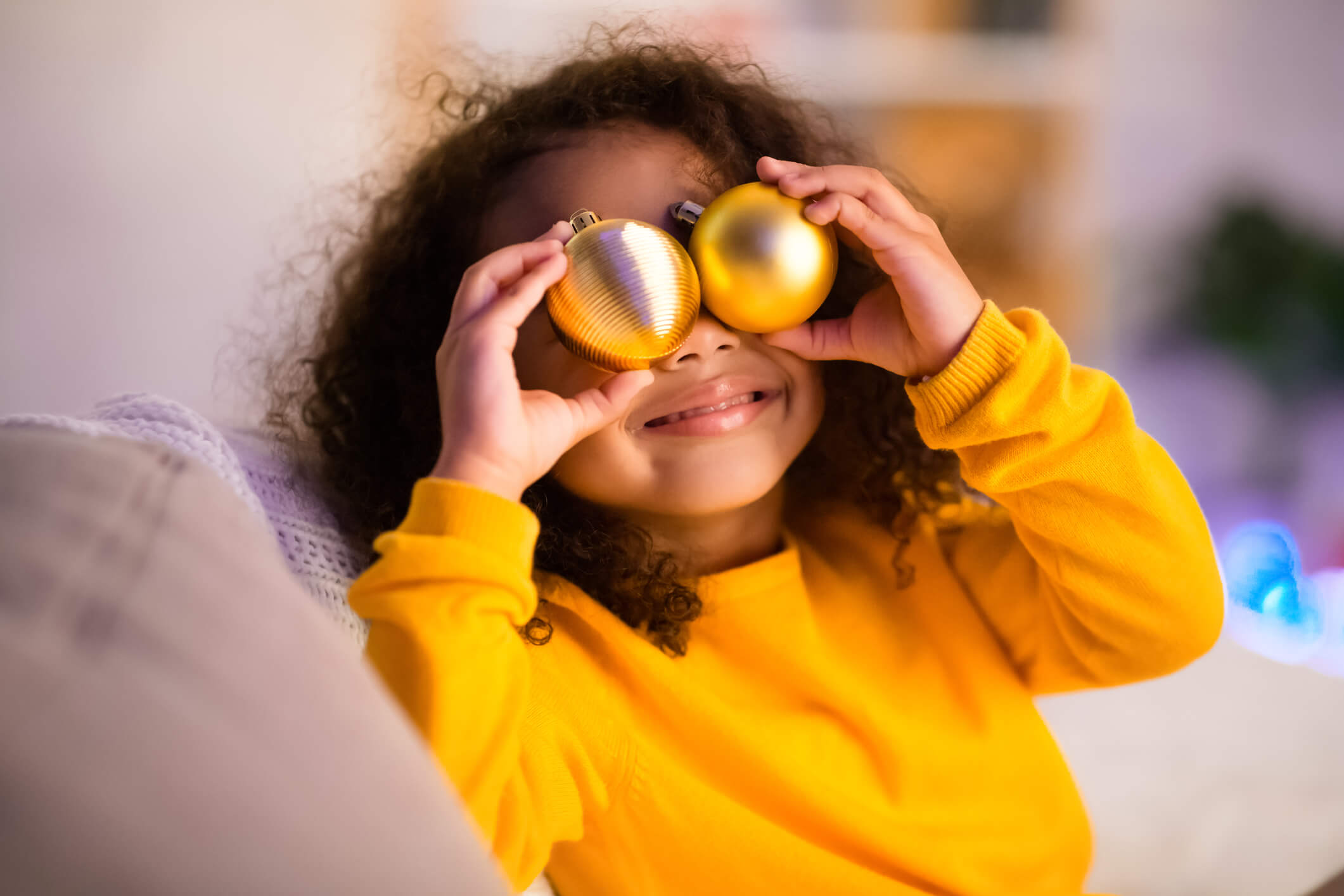 Cute little black girl playing with balls for Christmas tree