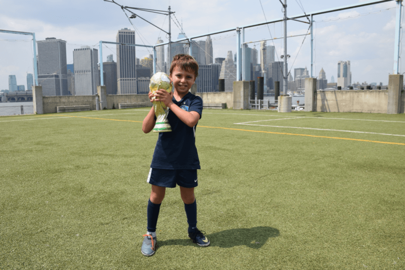 child holding trophy at french football academy