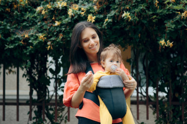 Mother Walking Baby Outdoors in Baby Wearing System
