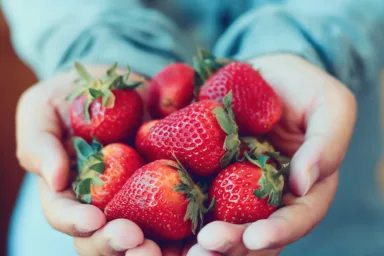 holding fresh strawberry