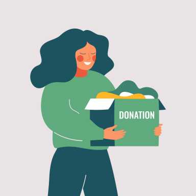 Volunteer woman holds donation box with old used clothes ready to be donated or recycled.