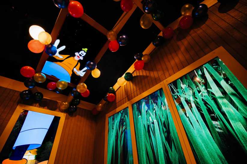 The file "Goofy-Main-Cabin-822x548.jpg" shows a whimsical room with colorful balloons on the ceiling, cartoon images of Goofy, and large windows with green plant designs.
