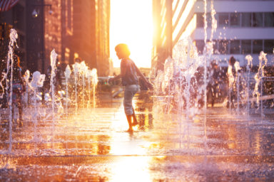 Happy boy run on fountain water Philadelphia city