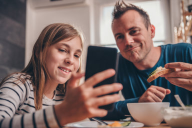 Daughter showing video on smart phone to a father