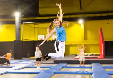 Teen girl jumping on trampoline on indoor inflatable playground