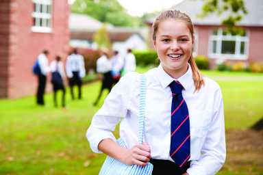 Portrait Of Female Teenage Student In Uniform Outside Buildings