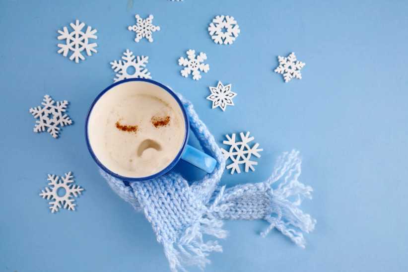 Blue monday concept. Sad face coffee mug wrapped in blue scarf