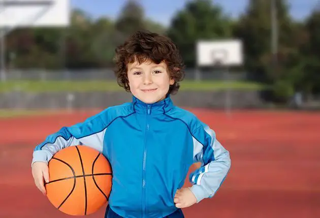 young boy with basketball on court