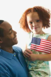 young girl holding american flag; fourth of july; family; father and daughter