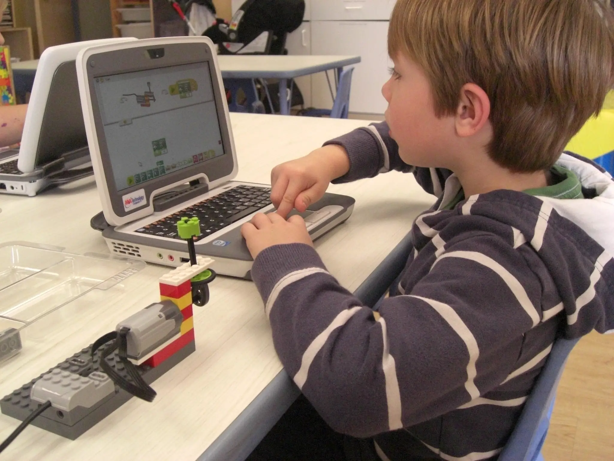 Max Crothall, 6, uses a computer to build and program a robot to move and make sound. Kids can do this at Bricks and Motors in Rye Brook, Westchester.
