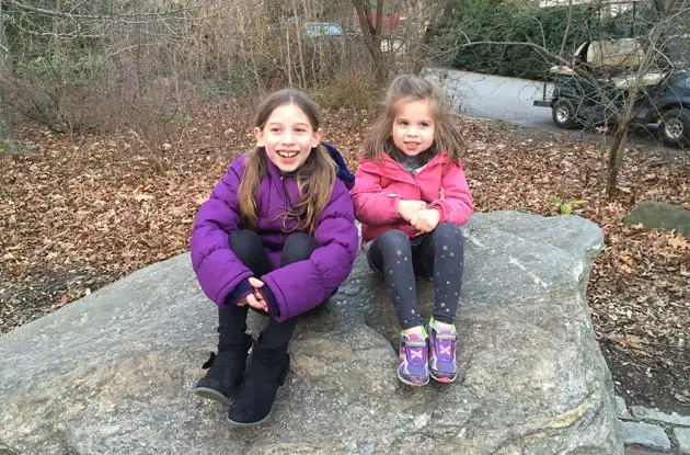 young girls sitting on a rock