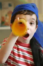 little boy looking through a tube, telescope; young boy playing pirate