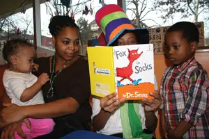 Family reading Dr. Seuss book at Brooklyn Chlldren's Museum; Reading Fox in Socks by Dr. Seuss