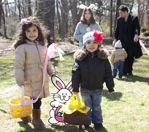 Easter egg hunt; two young girls holding Easter baskets
