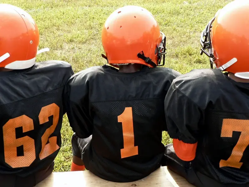 Young football players sitting on the sideline