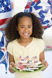 fourth of july; independence day; july 4; young girl holding plate of 4th of July cookies; little girl holding cookies