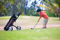 young boy playing golf; little boy hitting golf ball; golf lessons in Manhattan