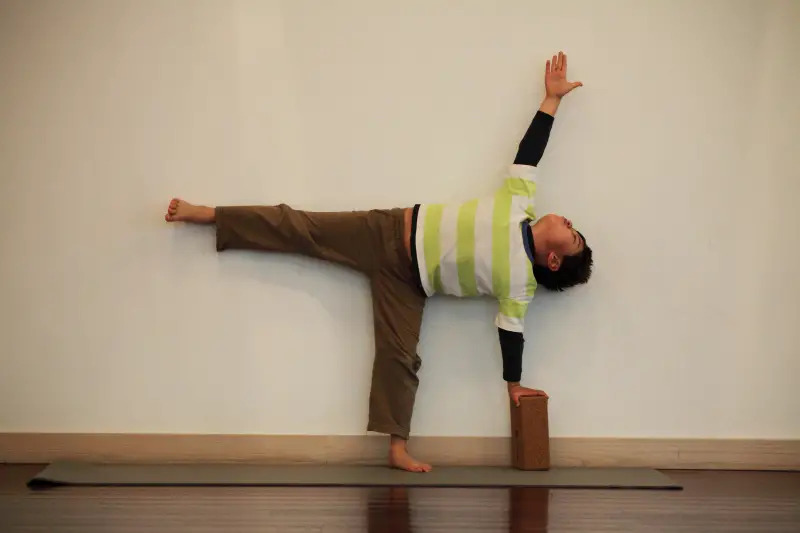 little boy doing yoga half-moon pose