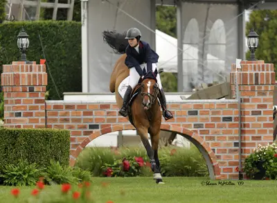 Hampton Classic Horse Show; huntseat rider jumping a brick wall; equestrian