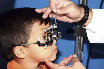 child getting vision checked; little boy at eye doctor's office, vision screening