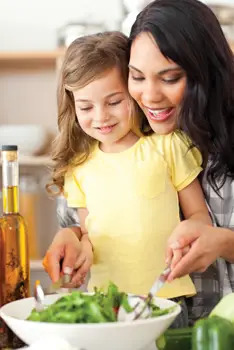 mom and daughter tossing a salad; preparing a healthy dinner