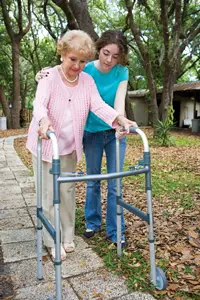young girl helping elderly woman with walker