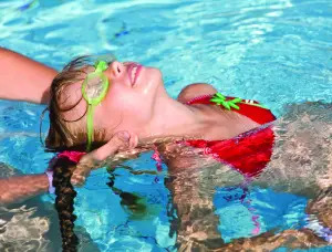 young girl learning to swim; child swimming