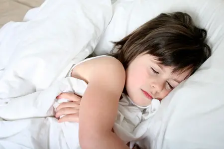 children's sleep disorders; young girl sleeping in big white bed