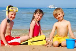 kids on beach; children playing on a beach, in the sand, in the water