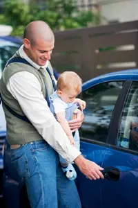 new dad with baby opening car door; father and child getting in a car; new father's survival guide