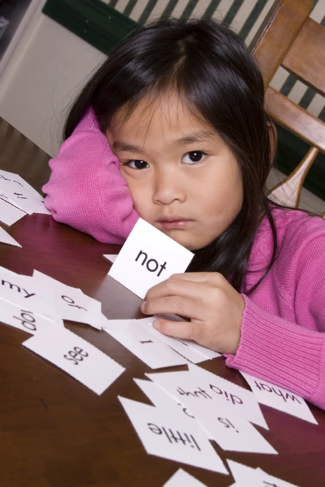 Sad young girl using flash cards learning vocabulary