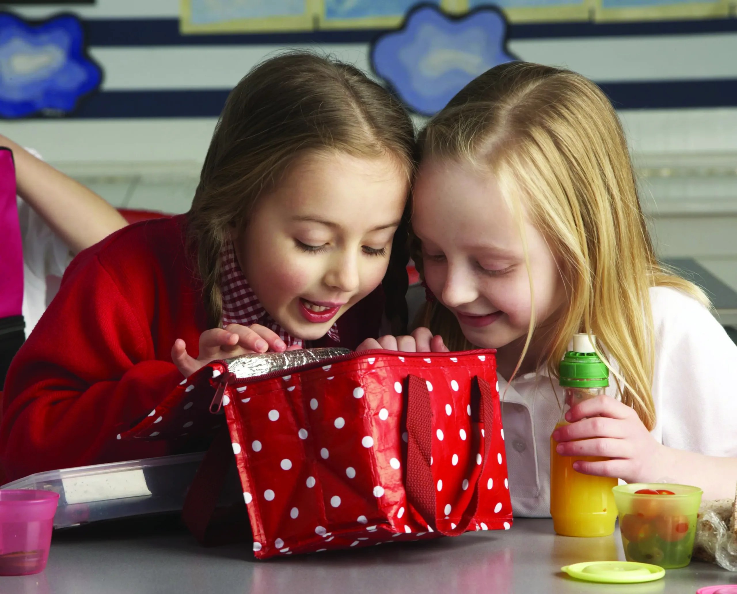 two young girls eating lunch at school