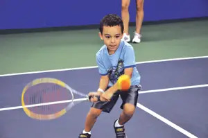 little boy playing tennis