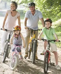 family riding bikes; family on bicycles with helmets