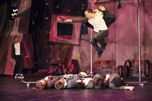 Traces cast member jumping over four other cast members