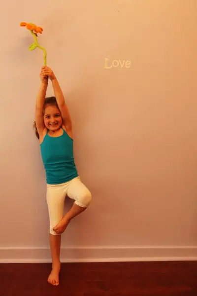 little girl doing yoga tree pose