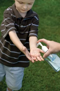 little boy using hand sanitizer; child using Purell