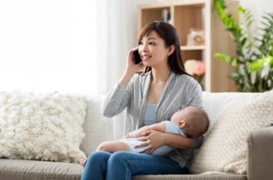 asian-mother-on-phone-holding-baby