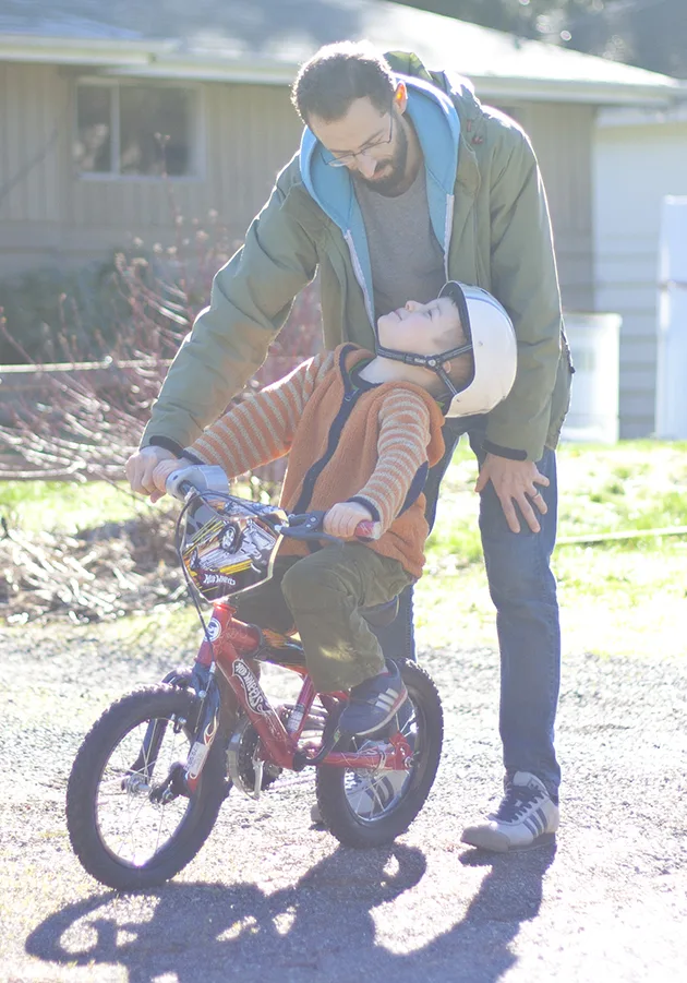 boy on bike talking to father