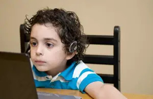 boy playing computer games, wearing headphones