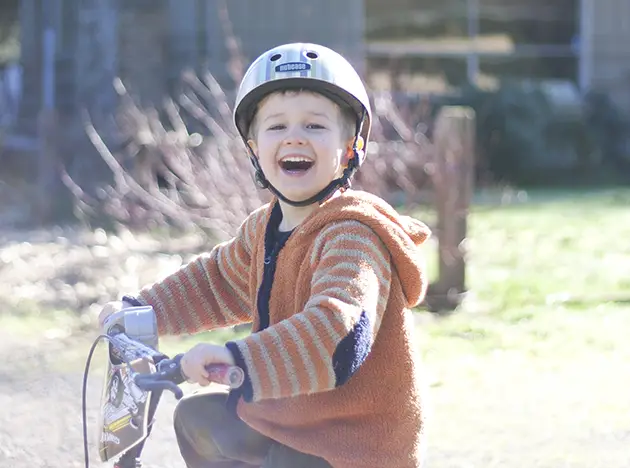 boy smiling riding bike
